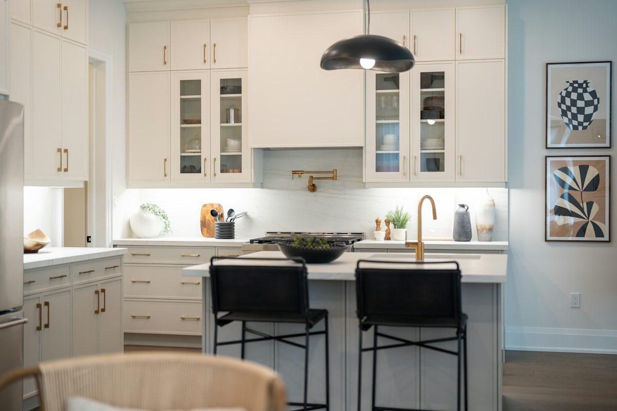 A bright kitchen with a white island and bar stools.