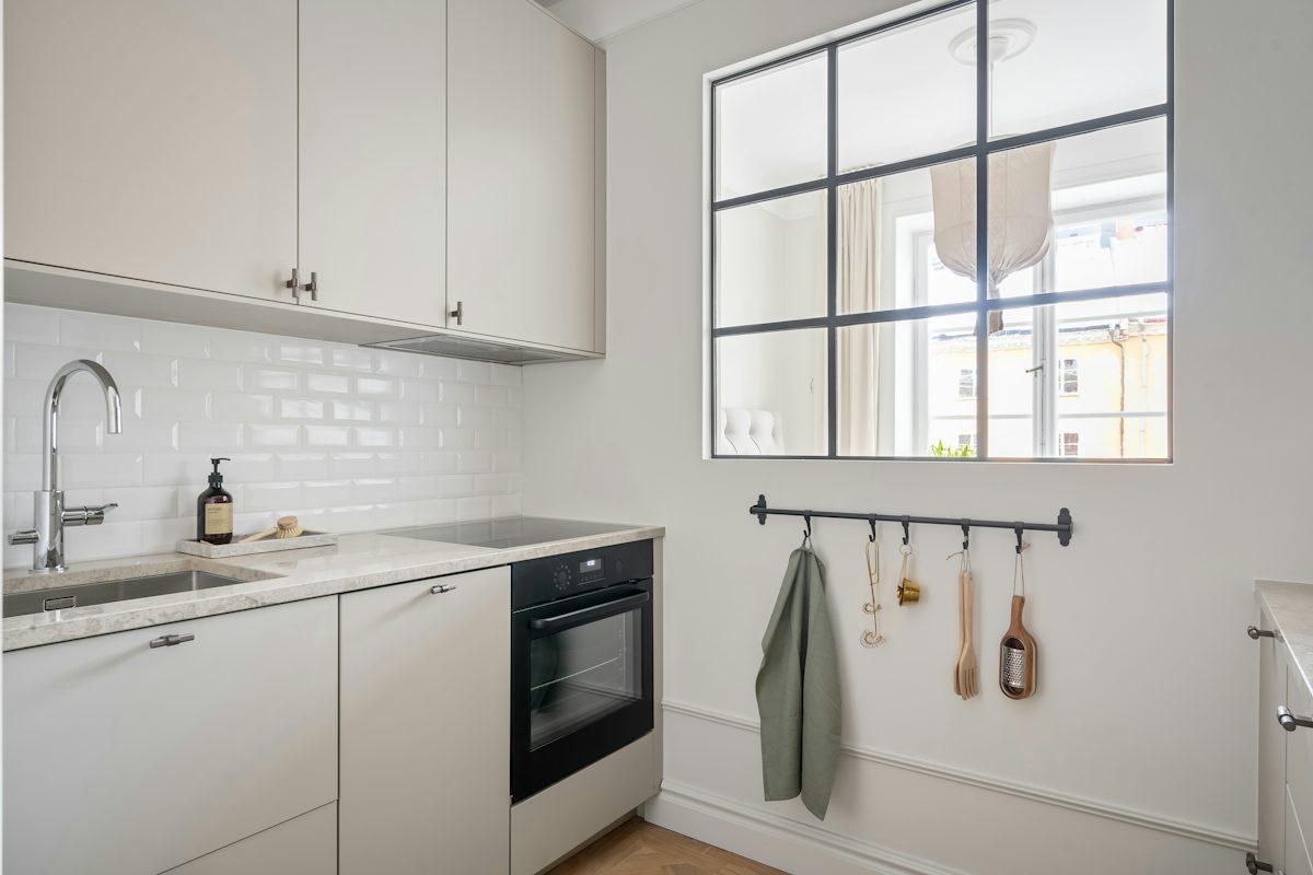 White kitchen cabinets beside a window.