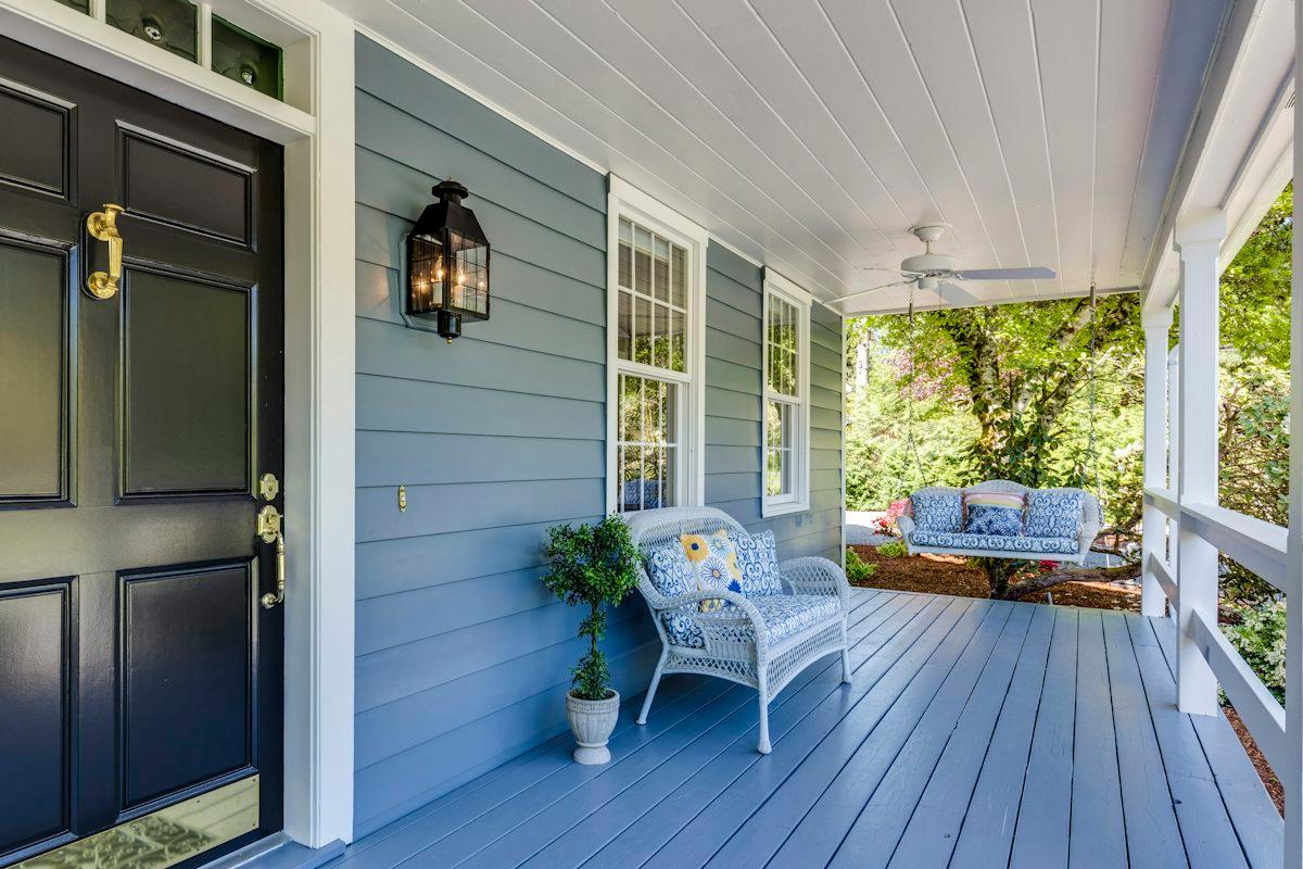 A porch with two chairs and a table.