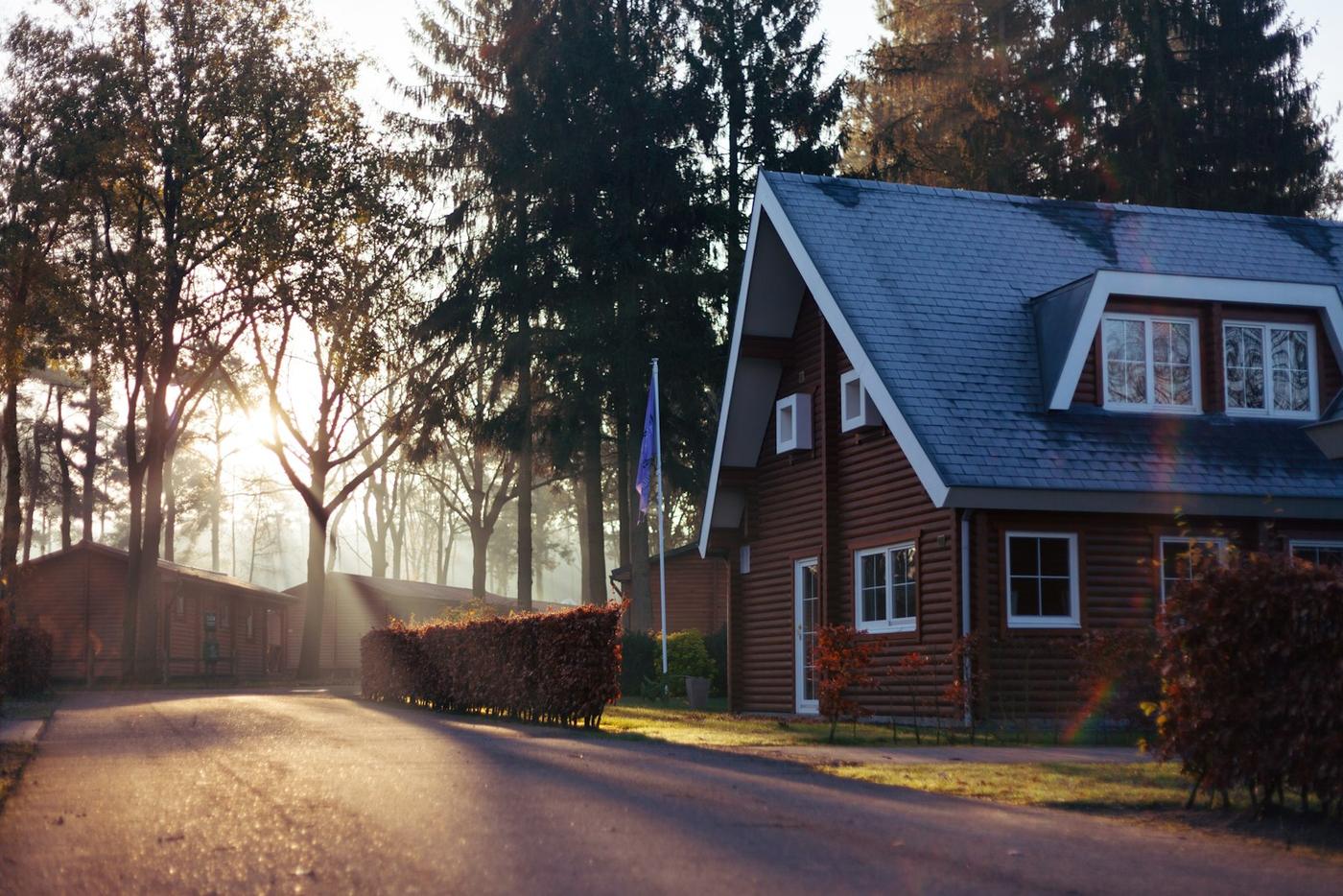 A brown and red house near trees.